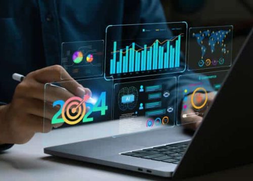 istockphoto-1828051105-612×612 Businessman works on laptop Showing 2024 business trends dashboard with charts, metrics, AI, E-commerce, KPI. analytical businessperson planning business growth 2024. New Year Future business tech.
